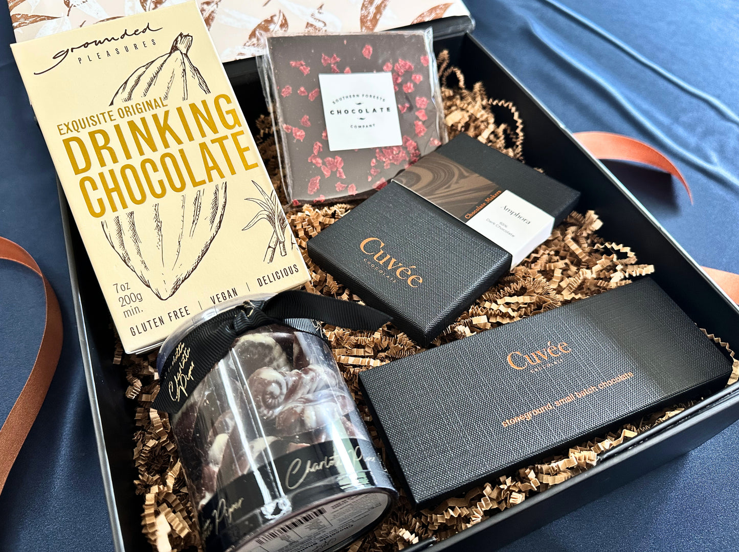 Gift box with Cuvée chocolate bars and other confections on magnetic gift box.