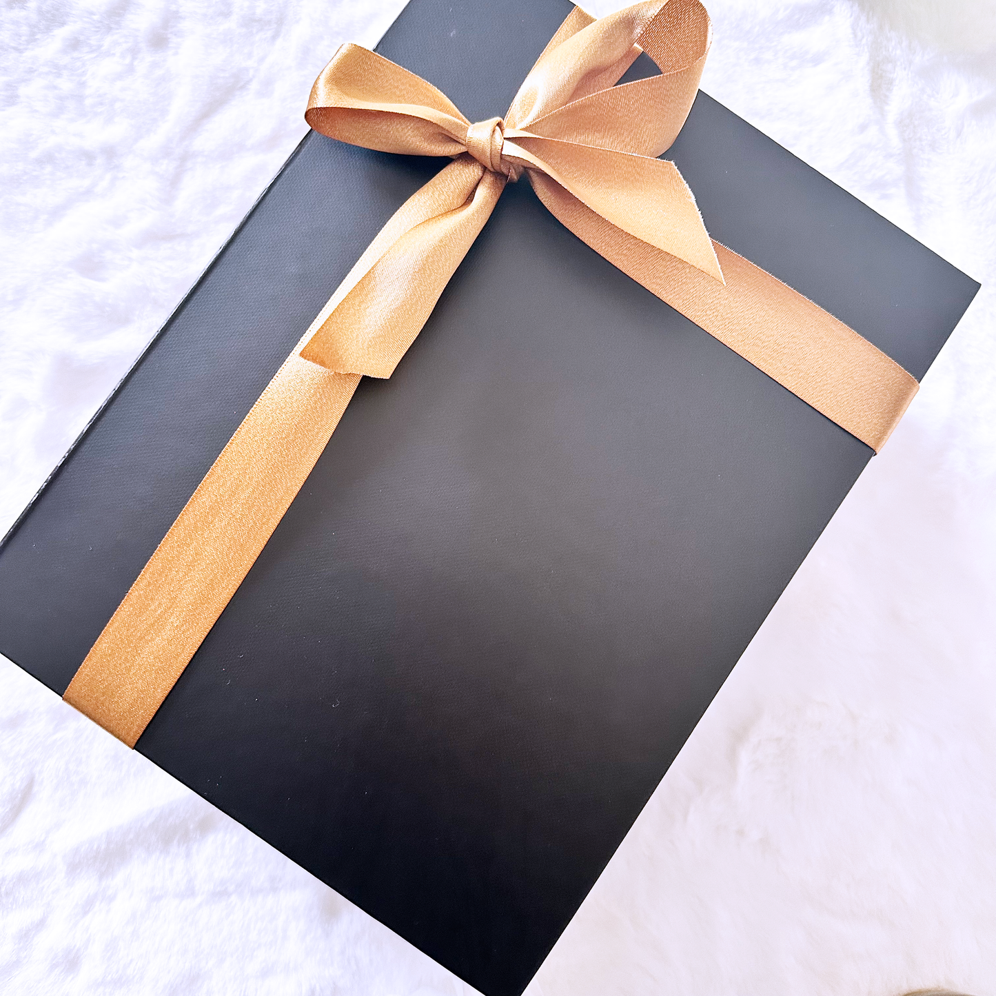 Black gift box with a gold ribbon