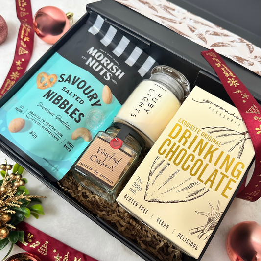 Christmas Gourmet Indulgence Gift Hamper with drinking chocolate, Morish Nuts, roasted cashews and a clear glass candle.