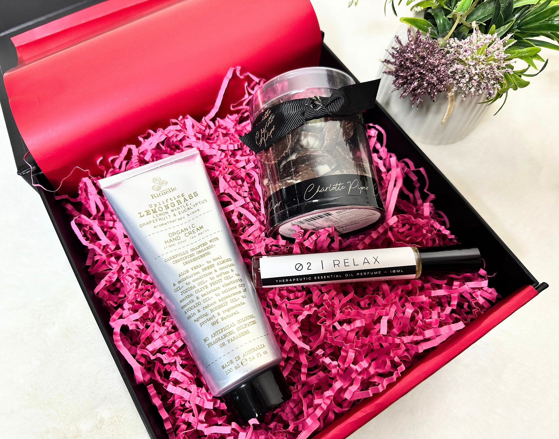Gifting set with lemongrass hand cream, relax essential oil perfume and handmade seashell chocolate  in a box with pink crinkle paper